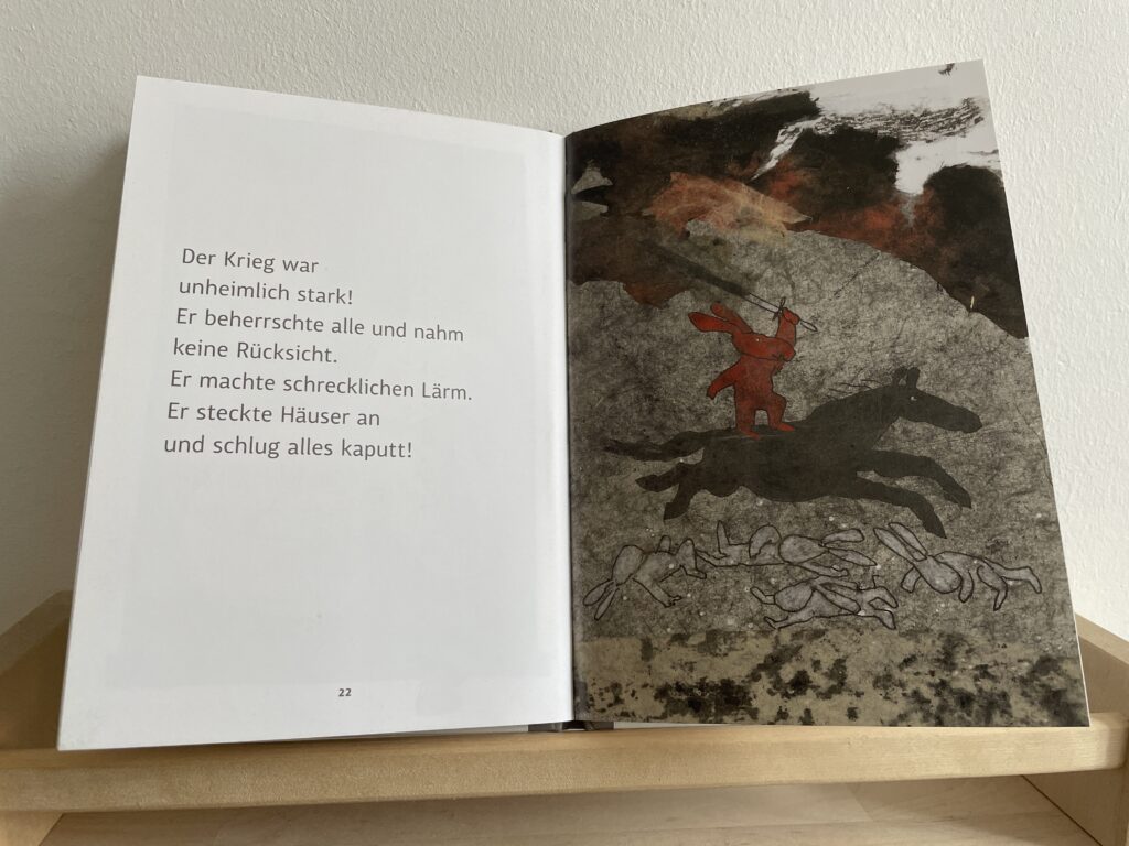 Das Foto zeigt eine Illustration des Buches zum Thema Krieg: ein Feldherr auf einem Pferd, der über Hasenleichen reitet. 